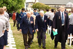 Guests and Veterans walk between the crosses
