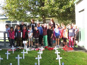 Children assembled by their Field of crosses