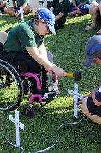 Girl hammering in a cross from her wheelchair