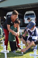 Teachers and pupil hammering in cross