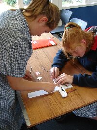 Students applying the name label to a cross